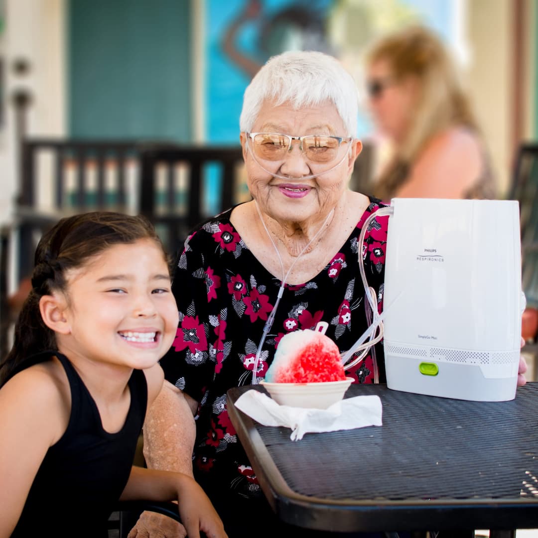 Grandmother with her granddaughter using the SimplyGo Mini Portable Oxygen Concentrator